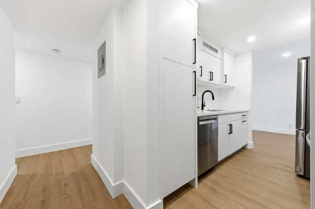 a kitchen with white cabinets and white appliances