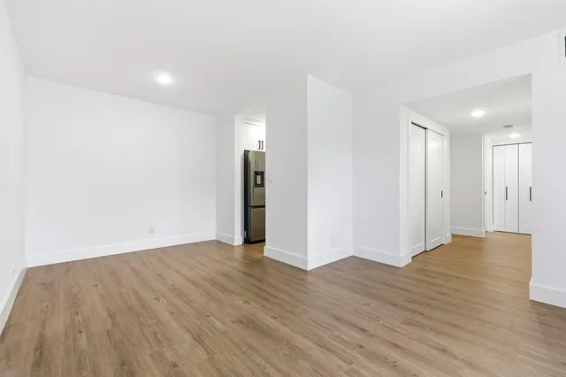 a view of an empty room with wooden floor