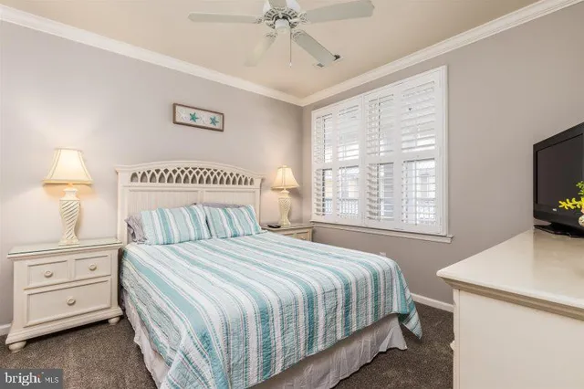 a bedroom with a bed and a flat tv screen on dresser