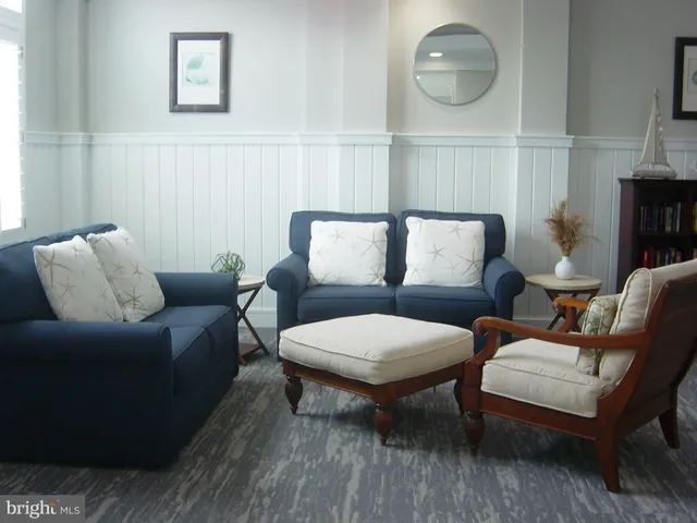 a living room with furniture a rug and a mirror