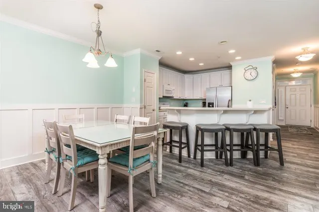 a view of a dining room and livingroom with furniture wooden floor a chandelier