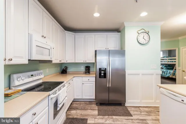 a kitchen with stainless steel appliances granite countertop a refrigerator a stove and a sink