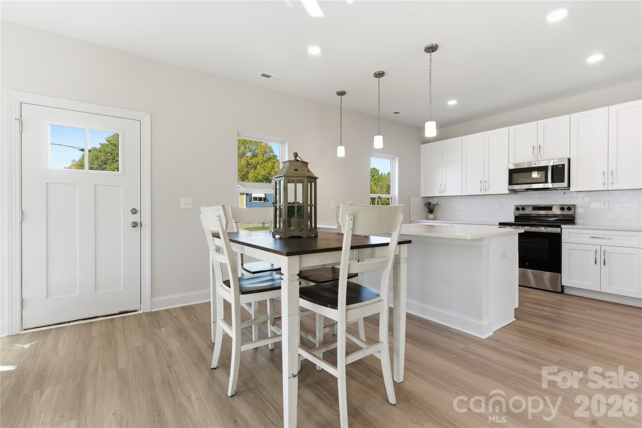 230 1st Street South Fort Mill, SC 29708 - Photo 2 of 22 a kitchen with a table chairs refrigerator and microwave