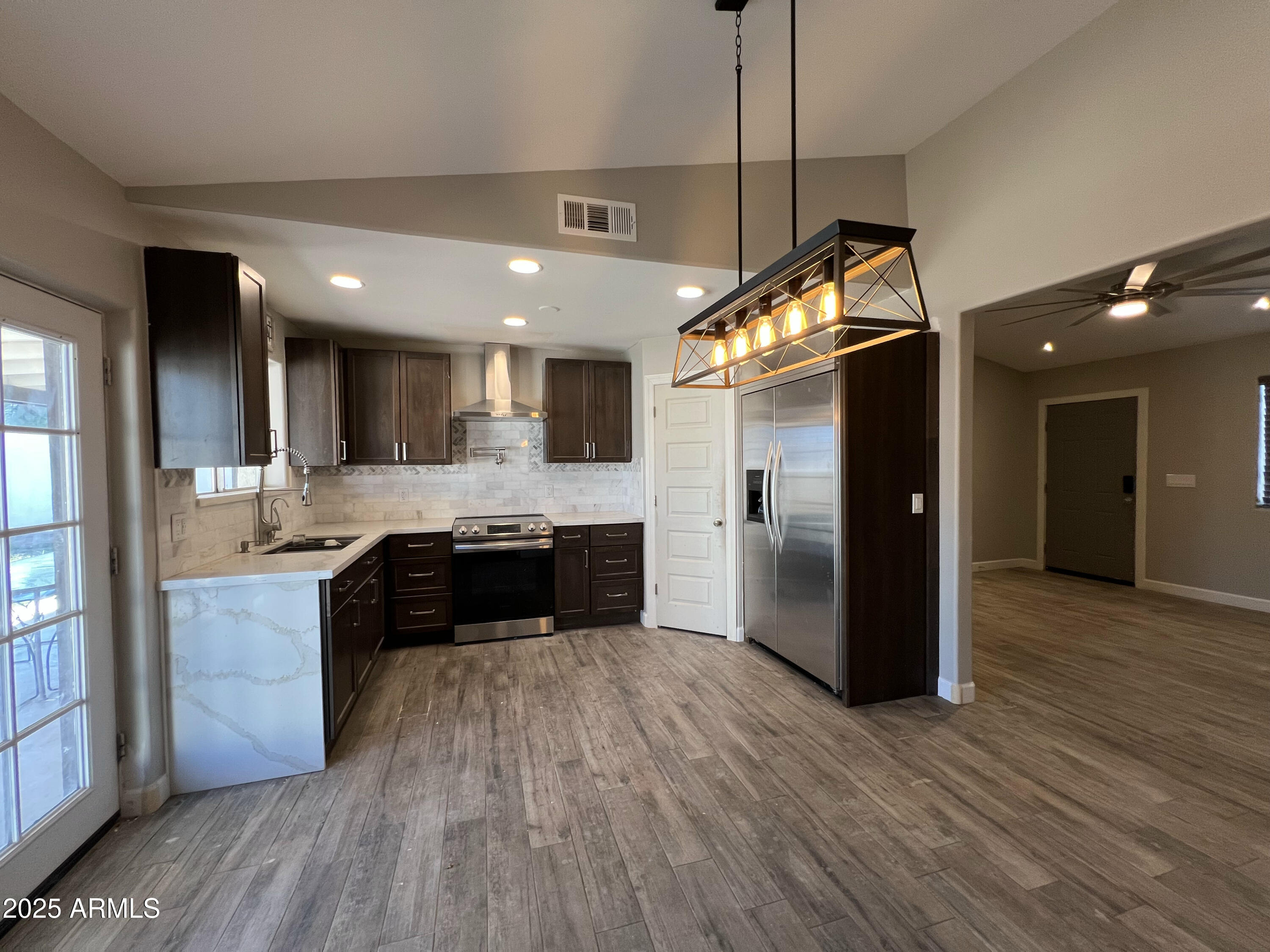 8201 South 26th Street Phoenix, AZ 85042 - Photo 12 of 42 a kitchen with stainless steel appliances granite countertop a refrigerator a sink a stove and a wooden floors
