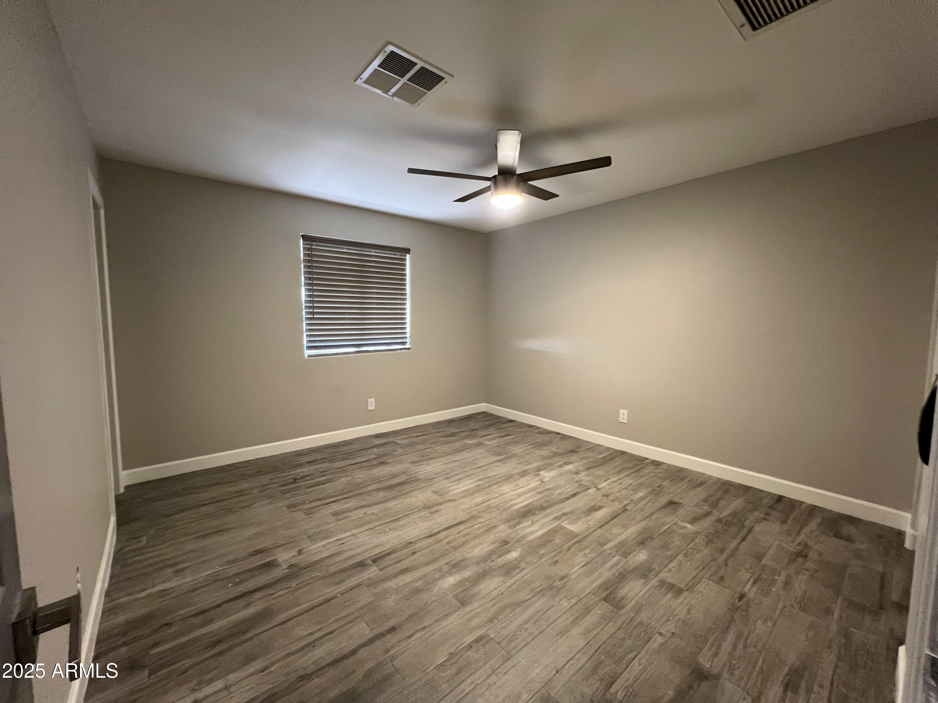 8201 South 26th Street Phoenix, AZ 85042 - Photo 17 of 42 an empty room with a window and a ceiling fan