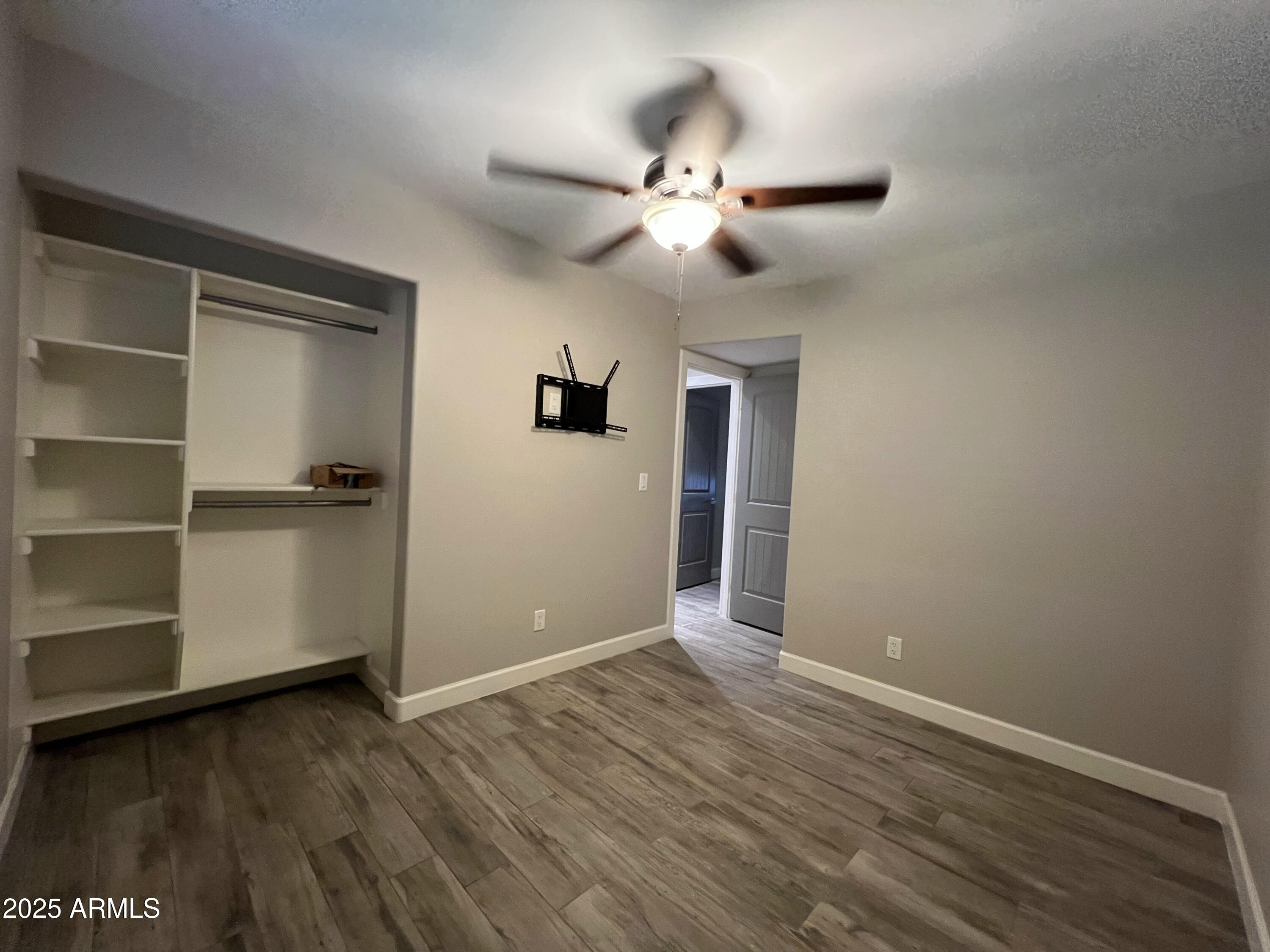 8201 South 26th Street Phoenix, AZ 85042 - Photo 22 of 42 a view of an empty room with a window and wooden floor
