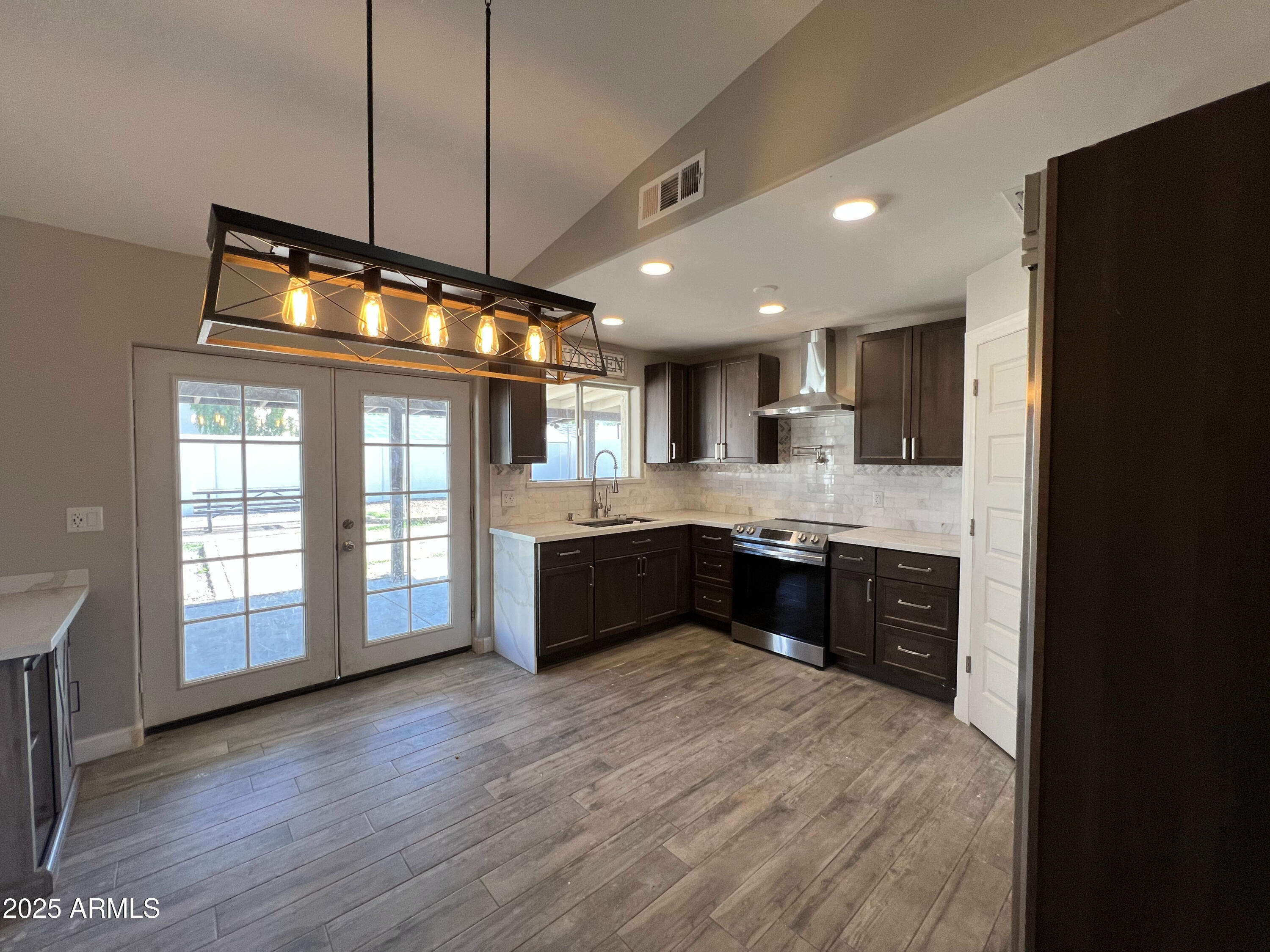 8201 South 26th Street Phoenix, AZ 85042 - Photo 27 of 42 a large kitchen with stainless steel appliances granite countertop a refrigerator a sink dishwasher a stove and a wooden cabinets