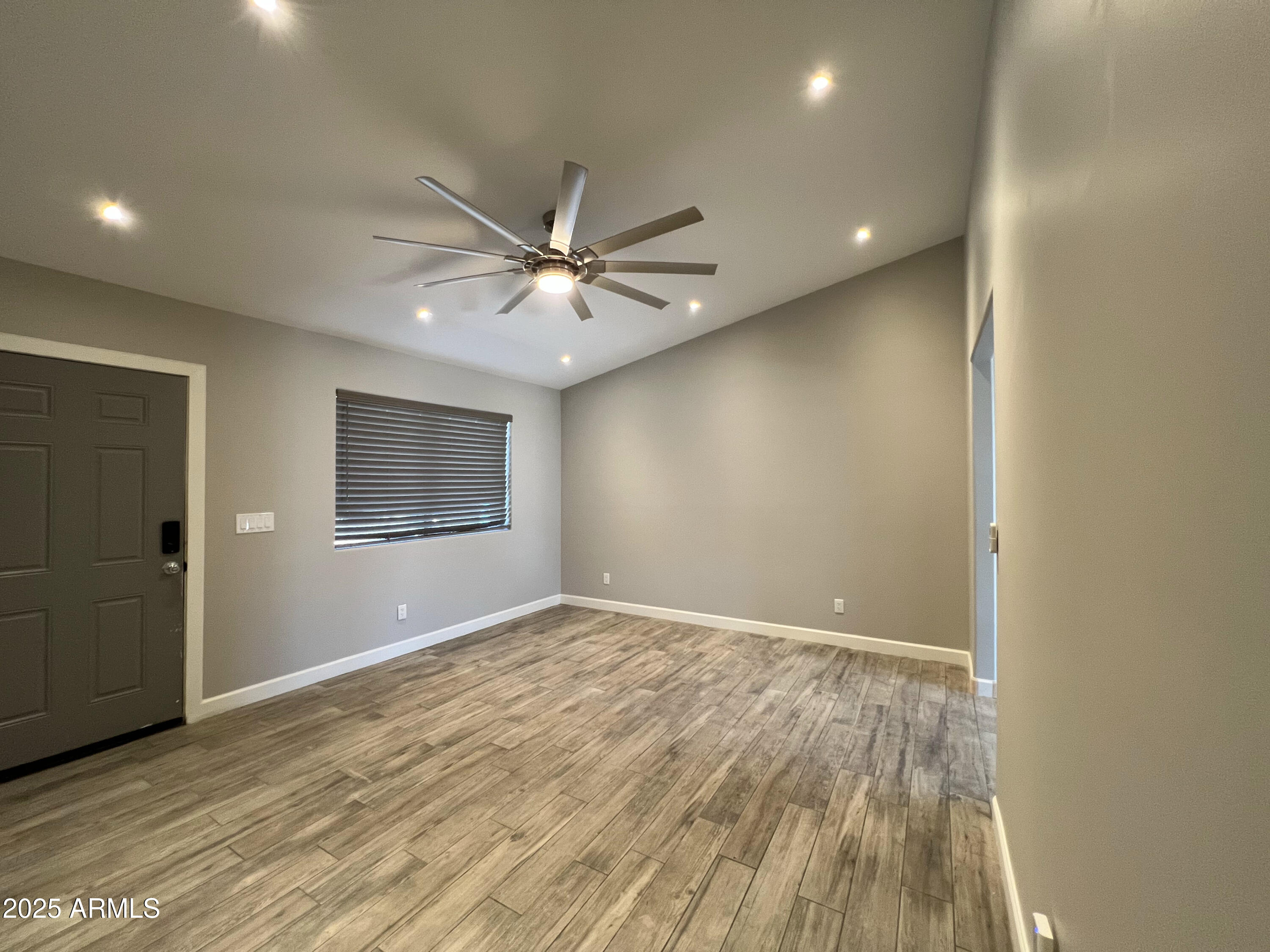 8201 South 26th Street Phoenix, AZ 85042 - Photo 4 of 42 an empty room with wooden floor and windows