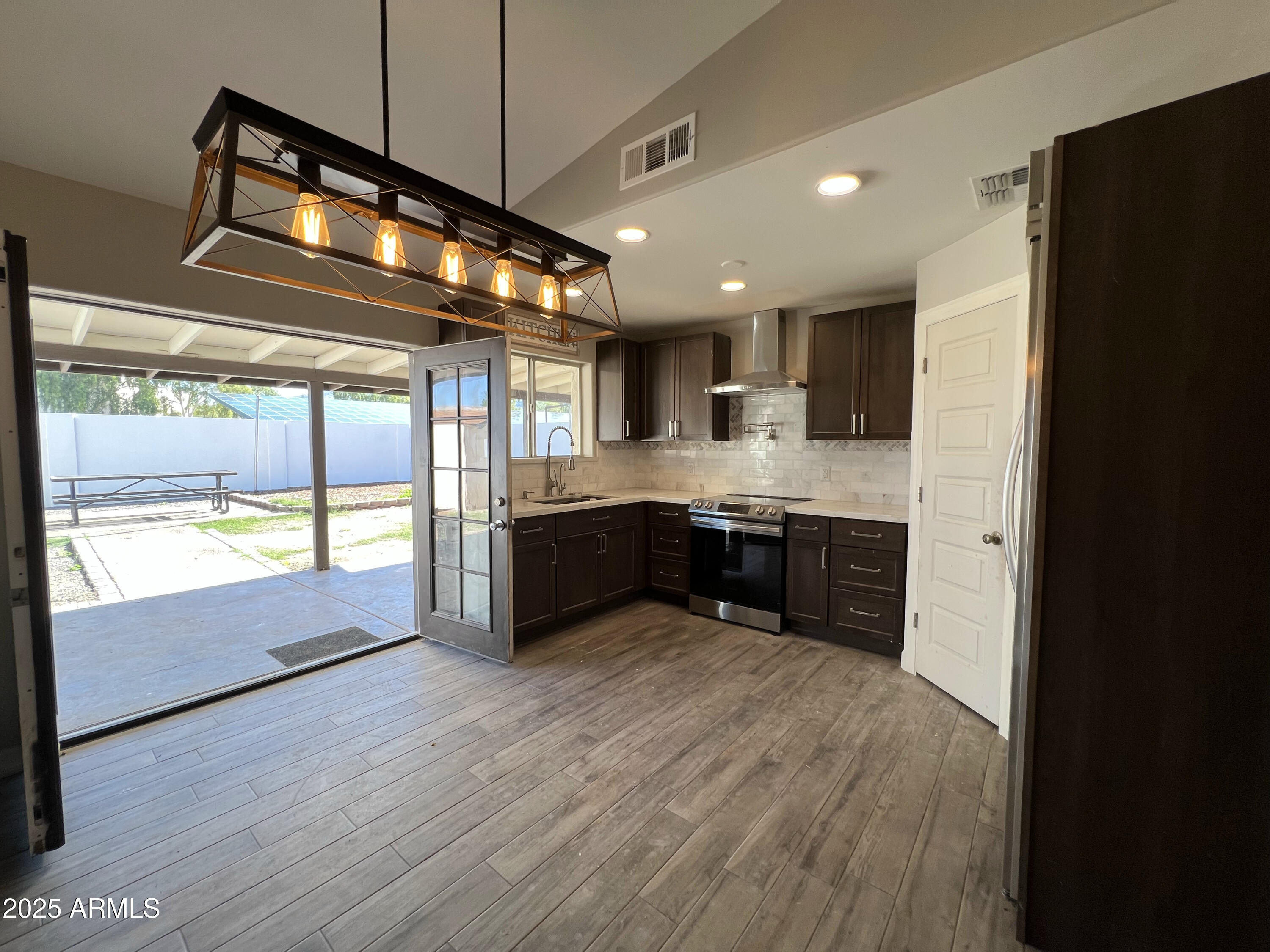 8201 South 26th Street Phoenix, AZ 85042 - Photo 7 of 42 a large kitchen with stainless steel appliances granite countertop a stove a sink and a refrigerator