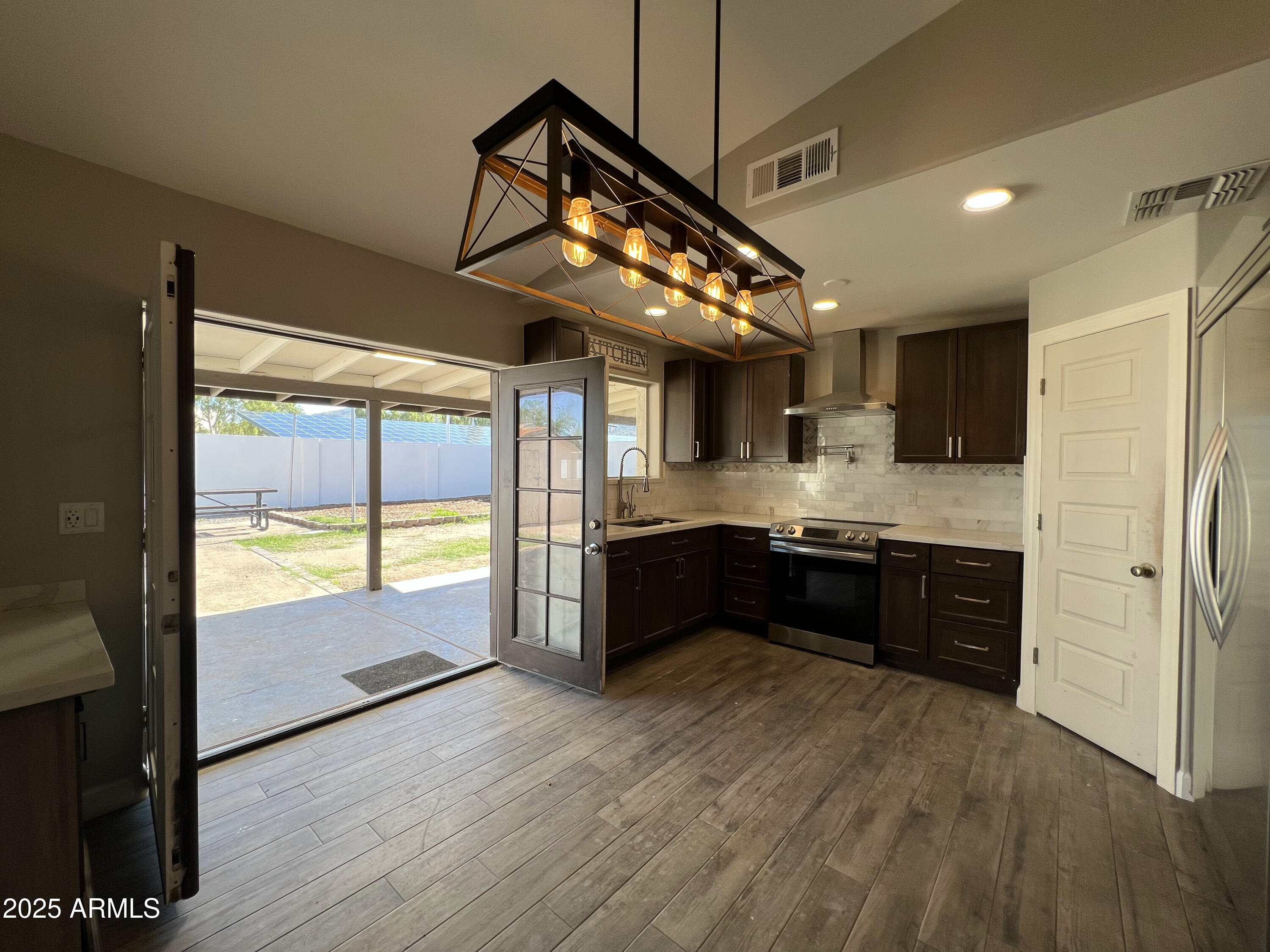 8201 South 26th Street Phoenix, AZ 85042 - Photo 8 of 42 a kitchen with stainless steel appliances granite countertop a refrigerator a sink dishwasher a stove and white countertops with wooden floor