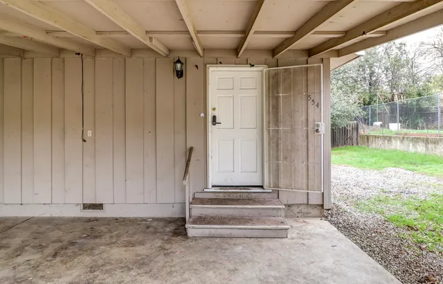 a view of a porch with wooden walls and a yard