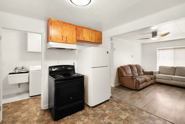 a living room with furniture windows and a refrigerator