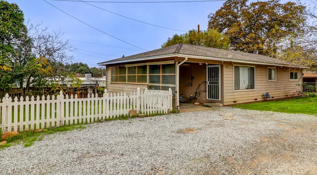 a view of a house with a small yard and wooden fence