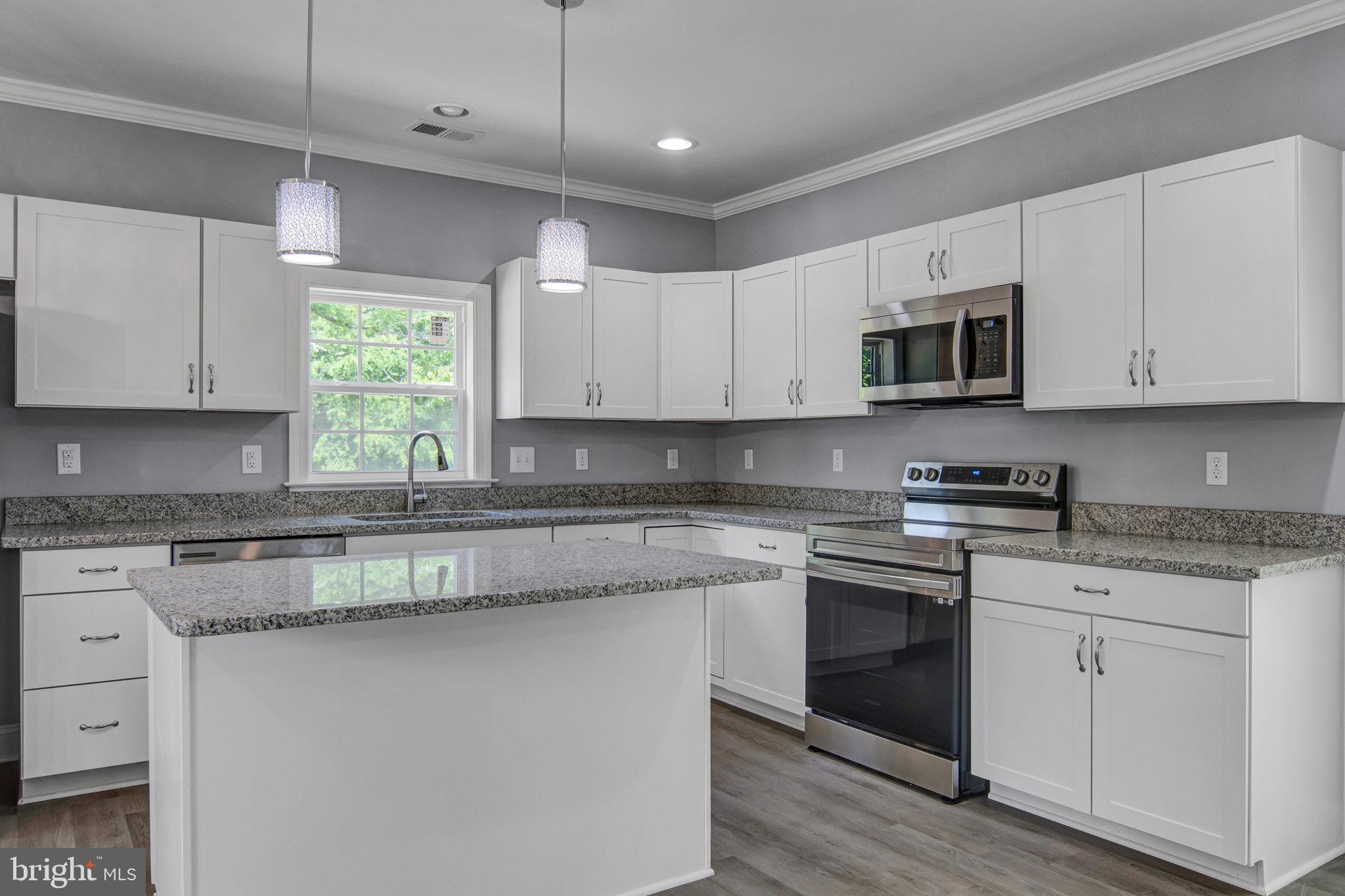 a kitchen with stainless steel appliances granite countertop white cabinets granite counter tops and a window
