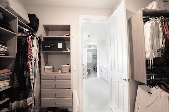 a view of walk in closet with clothes and shoes