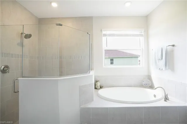 a bathroom with a white bath tub and a window