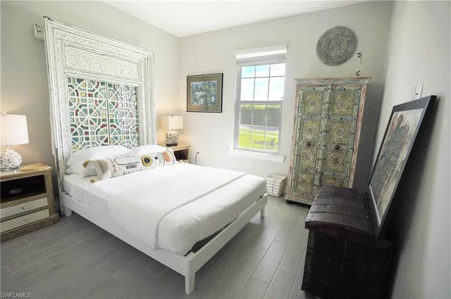 a bedroom with a bed a mirror and a window