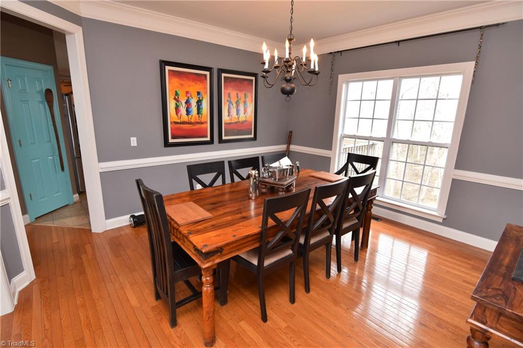 704 Number Ten Way Oak Ridge, NC 27310 - Photo 5 of 30 Formal dining room with hardwood floors, lots of natural light and detailed crown molding