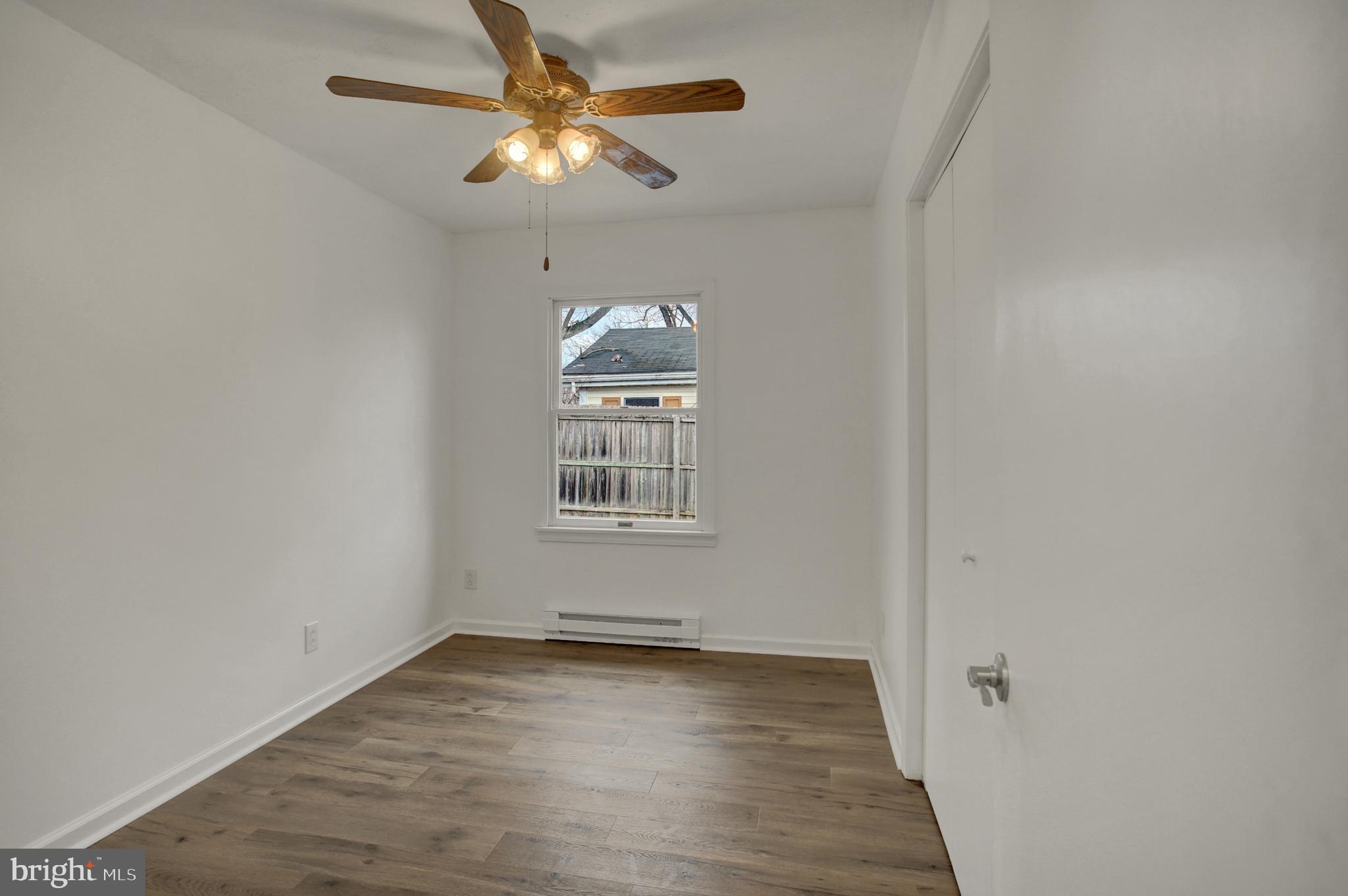 16944 Shinham Road Hagerstown, MD 21740 - Photo 19 of 29 an empty room with wooden floor chandelier fan and windows