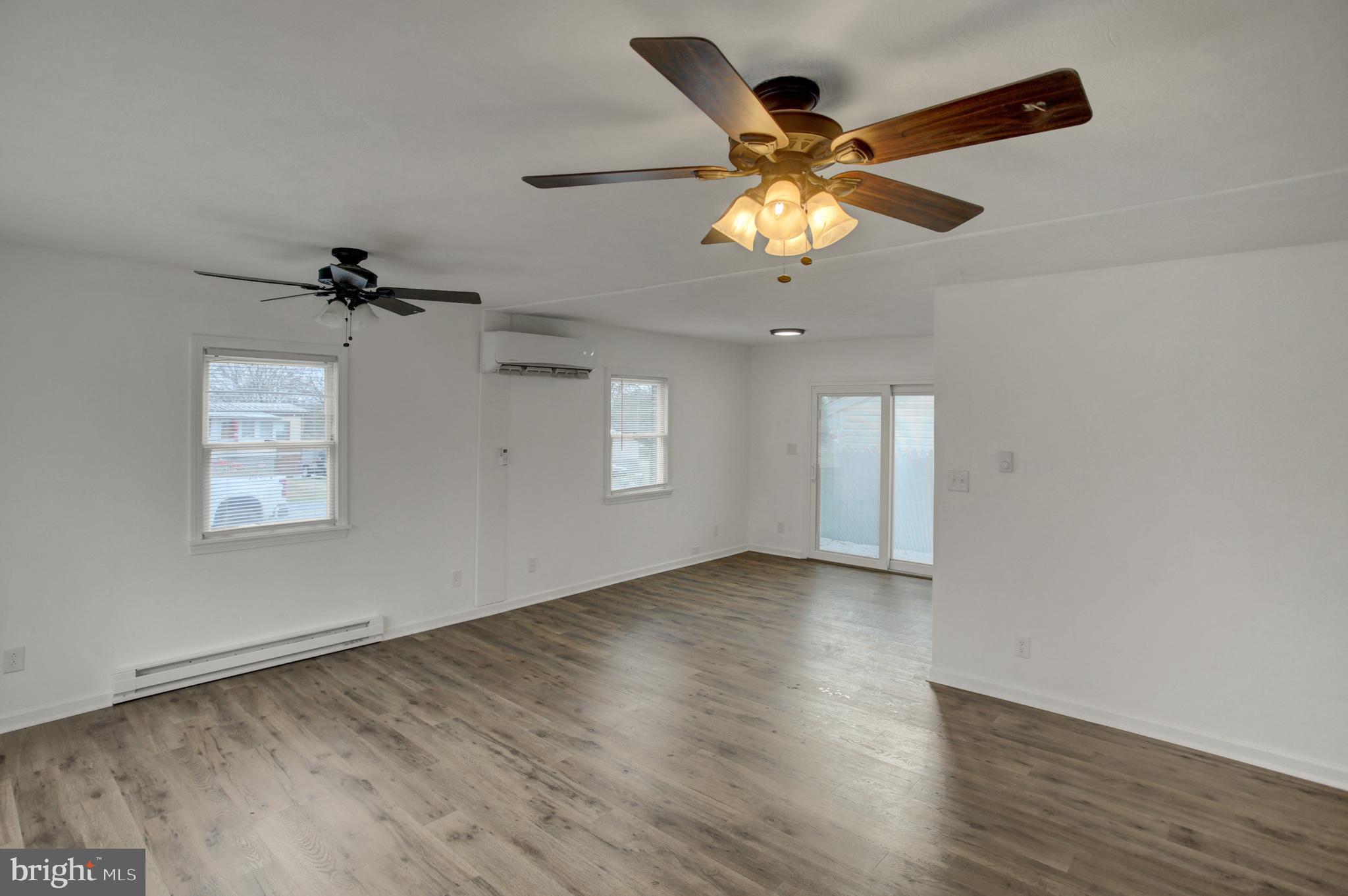 16944 Shinham Road Hagerstown, MD 21740 - Photo 3 of 29 an empty room with wooden floor fan and windows
