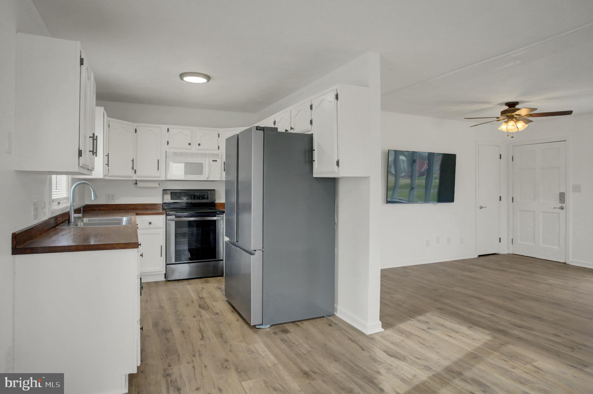 16944 Shinham Road Hagerstown, MD 21740 - Photo 4 of 29 a kitchen with granite countertop a refrigerator and a stove top oven