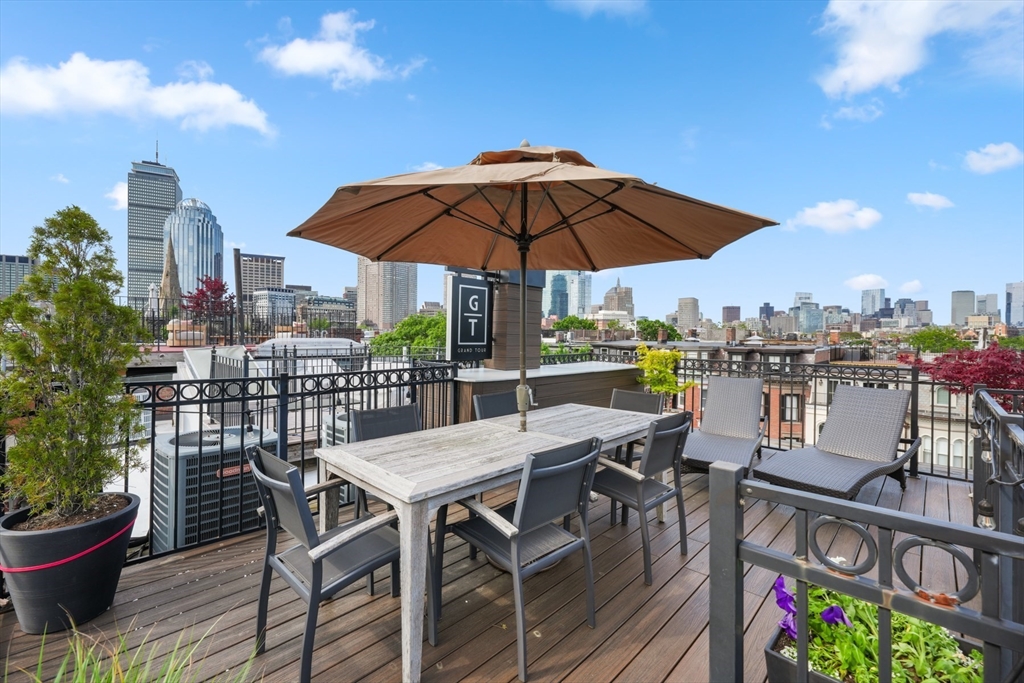 22 Rutland Square, Unit 2 Boston, MA 02118 - Photo 39 of 42 a view of a roof deck with table and chairs under an umbrella