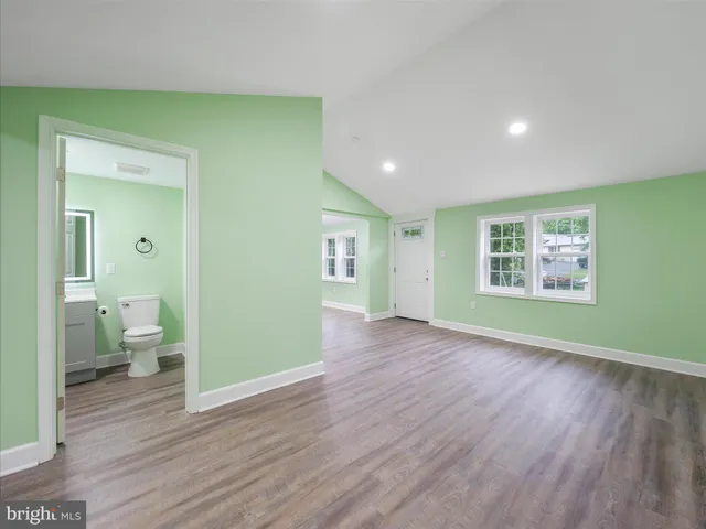 a view of a room with wooden floor and a bathroom