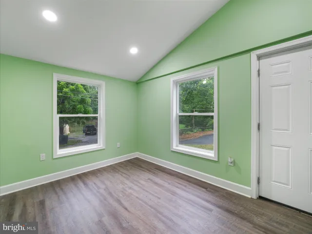 an empty room with wooden floor and a window