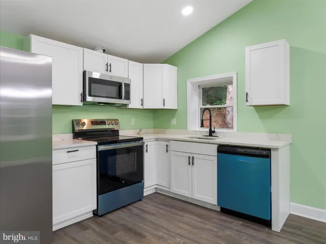a kitchen with stainless steel appliances granite countertop a stove a sink and a microwave