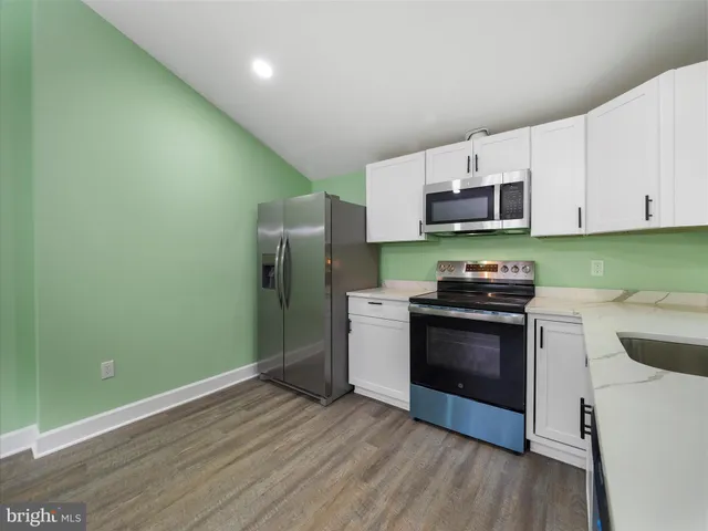 a kitchen with stainless steel appliances a stove a microwave and sink