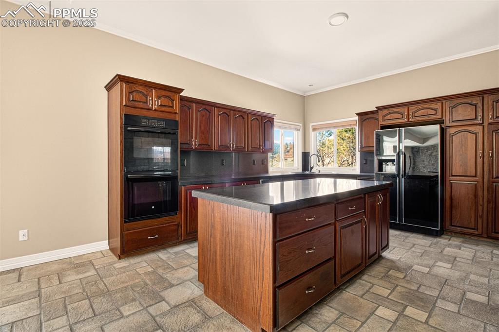 13950 Herring Road Colorado Springs, CO 80908 - Photo 13 of 50 a kitchen with granite countertop a refrigerator and a stove