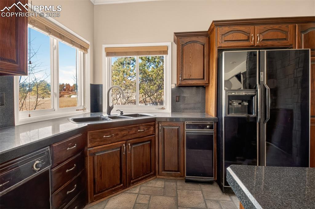 13950 Herring Road Colorado Springs, CO 80908 - Photo 15 of 50 a kitchen with a refrigerator a sink and cabinets