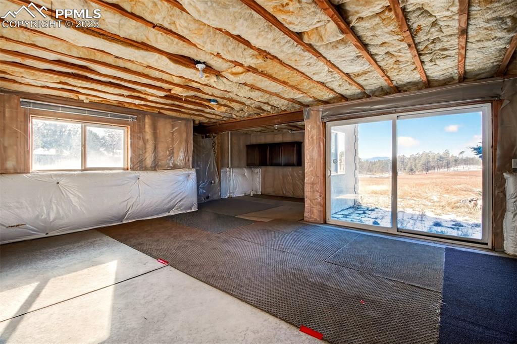 13950 Herring Road Colorado Springs, CO 80908 - Photo 23 of 50 a view of an empty room with a fireplace and a window