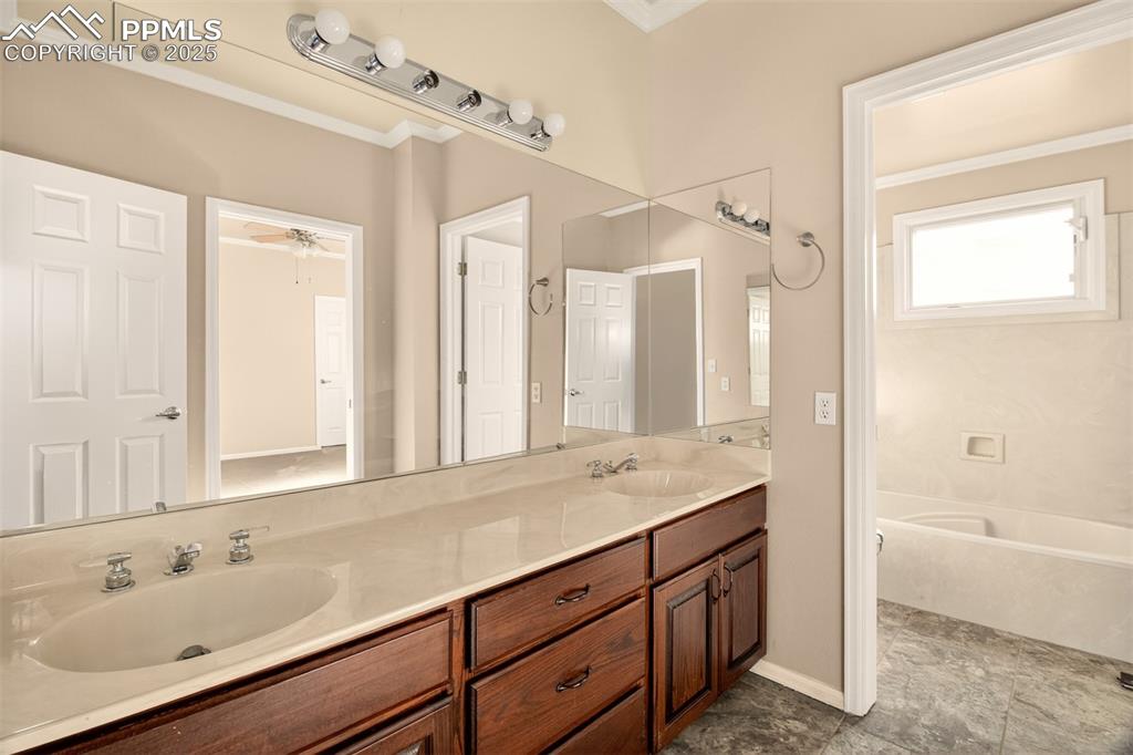 13950 Herring Road Colorado Springs, CO 80908 - Photo 33 of 50 a bathroom with a sink double vanity granite tub shower and a mirror