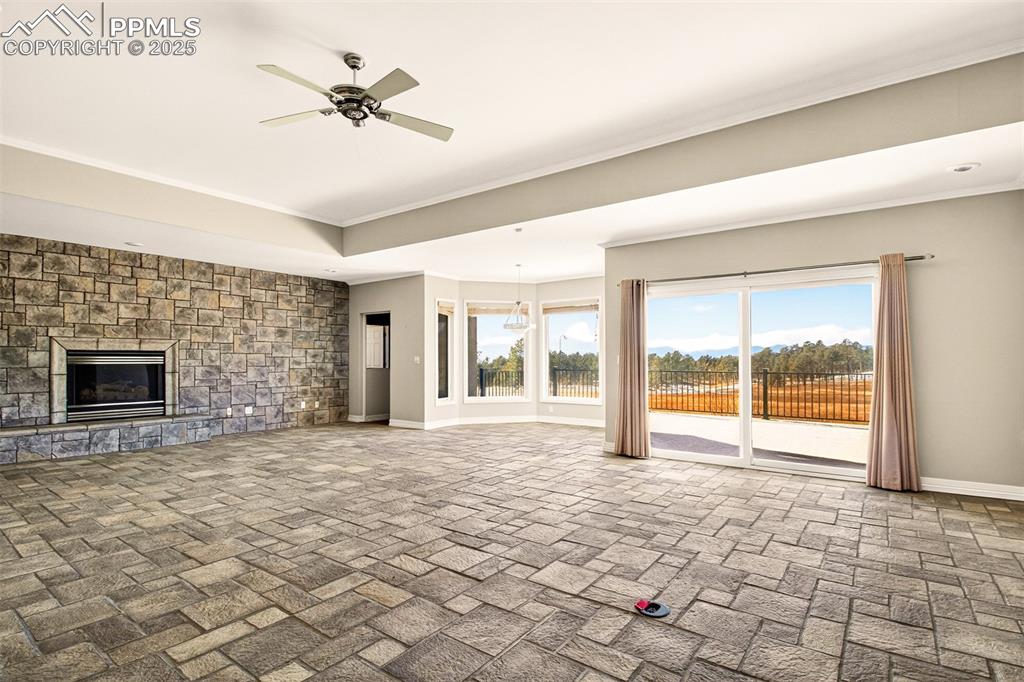 13950 Herring Road Colorado Springs, CO 80908 - Photo 4 of 50 a view of an empty room with a fireplace and a window