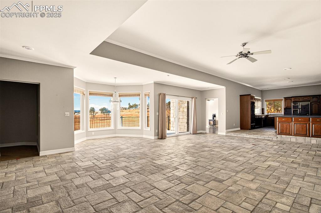 13950 Herring Road Colorado Springs, CO 80908 - Photo 5 of 50 a big room with chandelier fan and windows