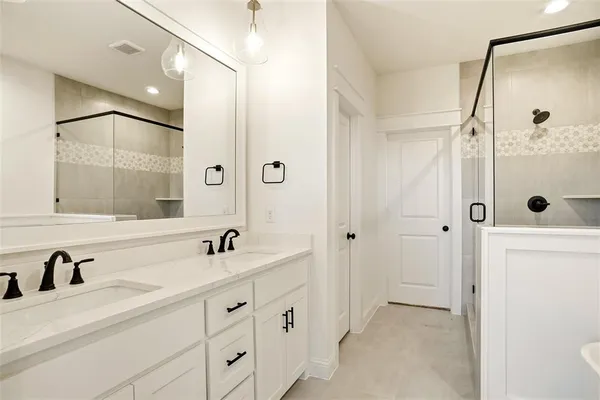 a bathroom with a double vanity sink mirror double and shower