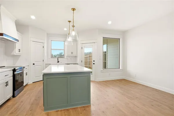 a kitchen with kitchen island a sink stainless steel appliances and cabinets