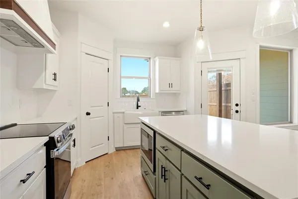 a kitchen with a sink appliances and cabinets