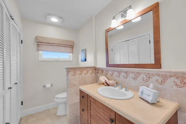 a bathroom with a toilet sink and mirror