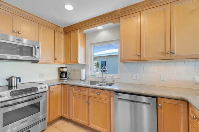 a kitchen with stainless steel appliances granite countertop a sink a stove and cabinets