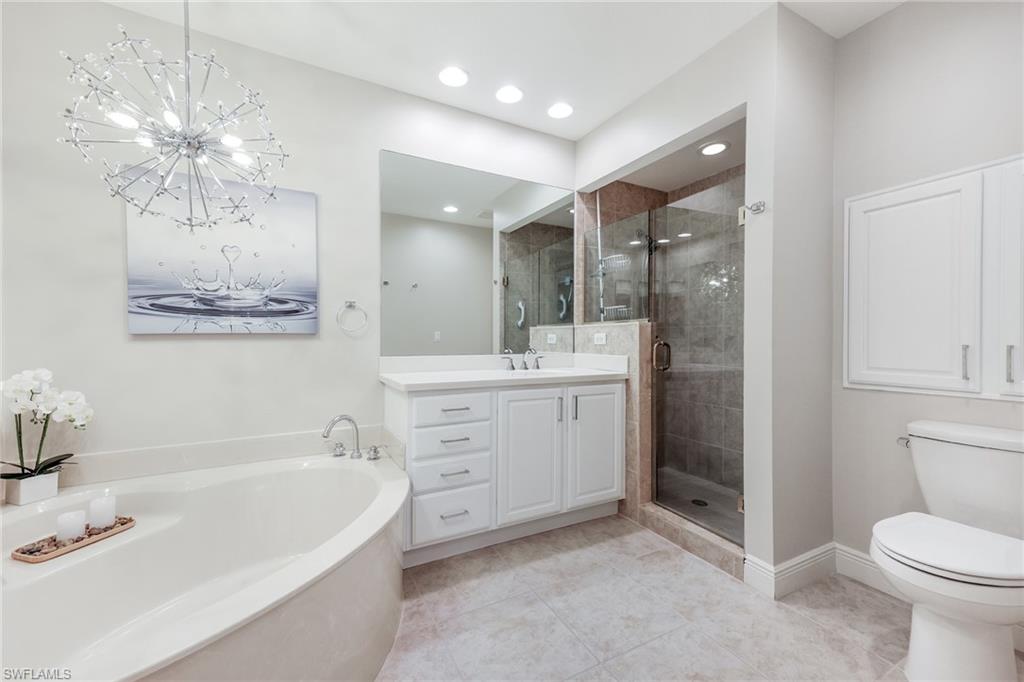 7849 Hawthorne Drive, Unit 802 Naples, FL 34113 - Photo 17 of 49 Full bathroom featuring an inviting chandelier, tile patterned flooring, separate shower and tub, toilet, and vanity