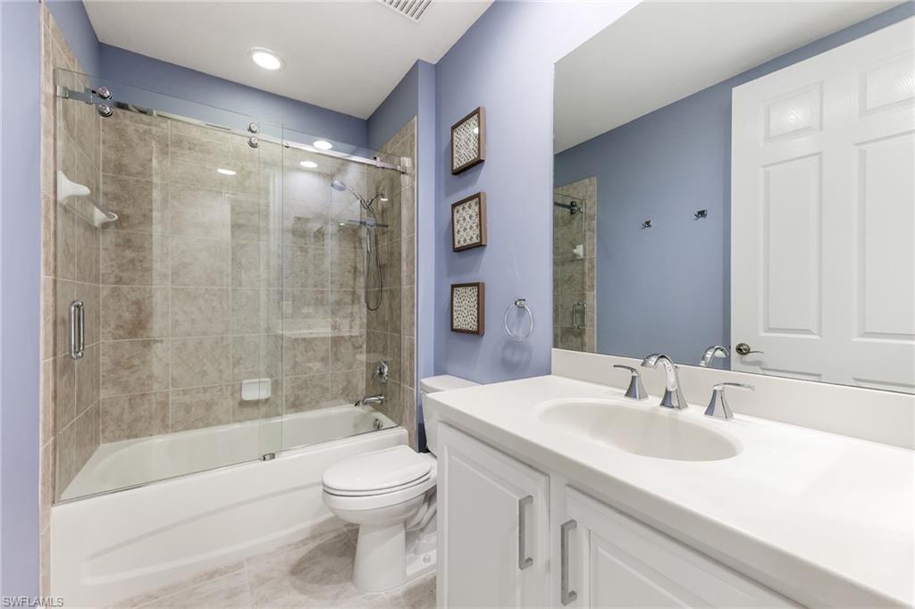 7849 Hawthorne Drive, Unit 802 Naples, FL 34113 - Photo 21 of 49 Full bathroom featuring tile patterned flooring, vanity, combined bath / shower with glass door, and toilet