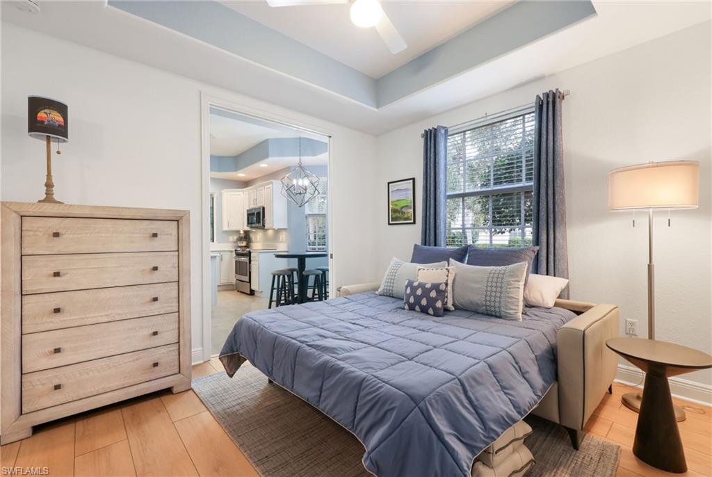 7849 Hawthorne Drive, Unit 802 Naples, FL 34113 - Photo 23 of 49 Den/Bedroom featuring a raised ceiling, ceiling fan with notable light hardwood / wood-style flooring