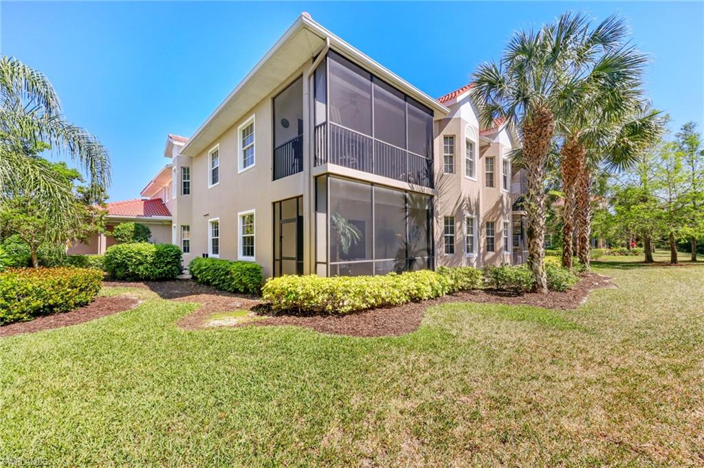 7849 Hawthorne Drive, Unit 802 Naples, FL 34113 - Photo 40 of 49 Back of property featuring a sunroom and a yard