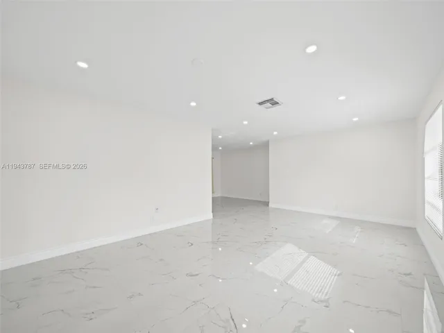 a view of a hallway with wooden floor and a bathroom