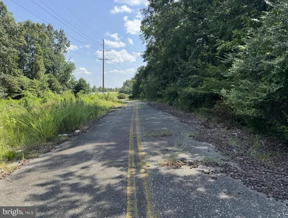 a view of a dirt road with a building in the background