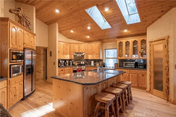 a kitchen with granite countertop wooden floors and white cabinets