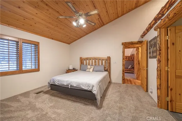 a bedroom with a large bed and a chandelier