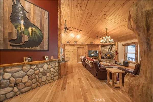 a living room with furniture a chandelier and wooden floor